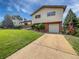 Charming two-story home with brick and siding, mature trees, an attached garage, and well-manicured lawn at 10371 Monterey Cir, Northglenn, CO 80260