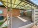 View of the covered patio featuring a brick wall, decorative ironwork, and a concrete floor at 10371 Monterey Cir, Northglenn, CO 80260