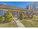 Charming home exterior featuring a brick facade, blue shutters, and a decorative front door at 13 Wedge Way, Littleton, CO 80123