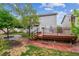 Spacious backyard featuring a wooden deck, stone pathway, mature trees, and well-maintained landscaping at 6519 Eastview St, Longmont, CO 80504