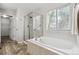 Bright bathroom features a soaking tub and glass enclosed shower, offering relaxation and convenience at 6519 Eastview St, Longmont, CO 80504