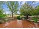 Lovely outdoor wooden deck with a view of the manicured lawn, trees, and playground area at 6519 Eastview St, Longmont, CO 80504