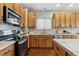 Bright kitchen featuring wood cabinets, stainless steel appliances, and tiled backsplash at 6519 Eastview St, Longmont, CO 80504