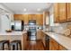 Well-lit kitchen with stainless steel appliances, tile backsplash, wooden cabinets and breakfast bar at 6519 Eastview St, Longmont, CO 80504