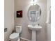 Clean powder room with pedestal sink, oval mirror, and neutral decor at 6519 Eastview St, Longmont, CO 80504