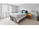 Neutral bedroom with tufted headboard, side table, plush carpet, and bright window at 8005 W Calhoun Pl, Littleton, CO 80123