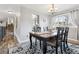 Elegant dining area with a chandelier, wood table, and large window for natural light at 8005 W Calhoun Pl, Littleton, CO 80123