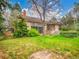 Spacious backyard features a brick chimney, large trees and a small deck at 8546 E Mineral Cir, Centennial, CO 80112