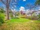 Lush green backyard with tiered planting beds and mature trees, creating a serene outdoor space at 8546 E Mineral Cir, Centennial, CO 80112