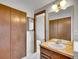 Bathroom featuring wooden-style cabinetry, a sink with a vanity, and a view into another bathroom at 8546 E Mineral Cir, Centennial, CO 80112