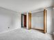 This bedroom includes neutral colored walls and carpet, an open closet, and wood trim at 8546 E Mineral Cir, Centennial, CO 80112
