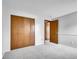 This bedroom features a closet with wood doors and neutral colored walls and carpeting at 8546 E Mineral Cir, Centennial, CO 80112