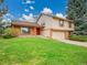 Two-story home boasts a red door, brick accents, tan siding, and well-maintained front lawn at 8546 E Mineral Cir, Centennial, CO 80112