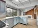 Cozy kitchen with a large window, stainless steel appliances, blue cabinets, and a view to the living area at 8546 E Mineral Cir, Centennial, CO 80112