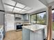 Charming kitchen features blue cabinets, stainless steel appliances, and a large window with views of the outdoors at 8546 E Mineral Cir, Centennial, CO 80112