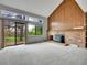 Light filled living room with a brick fireplace, wood paneling, and sliding glass doors to the back yard at 8546 E Mineral Cir, Centennial, CO 80112