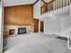 Spacious living room with a brick fireplace, built-in bookshelves, and a high ceiling with wood accents at 8546 E Mineral Cir, Centennial, CO 80112