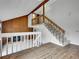 Spacious living room with a wood accent wall, brick fireplace, and a staircase leading to the upper level at 8546 E Mineral Cir, Centennial, CO 80112