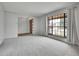 Spacious living room with neutral tones, plush carpeting, and a large window overlooking the front yard at 8546 E Mineral Cir, Centennial, CO 80112