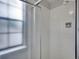 Shower with white tiling, a clear shower door, and fixtures at 8546 E Mineral Cir, Centennial, CO 80112