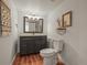 Bathroom features vanity with dark cabinets, framed mirror, and wood-look tile flooring at 7829 Nile Cir, Arvada, CO 80007
