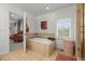 Elegant bathroom featuring a soaking tub, tiled walls, and views of the living room at 7829 Nile Cir, Arvada, CO 80007