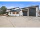 Side view showcasing the black garage doors and accent shutters of this two story home at 7829 Nile Cir, Arvada, CO 80007