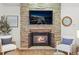 Stone fireplace with mantel and hearth and a TV mounted above at 7829 Nile Cir, Arvada, CO 80007