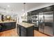 Open-concept kitchen with stainless steel appliances and dark kitchen island at 7829 Nile Cir, Arvada, CO 80007