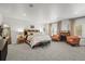 Bright main bedroom featuring a fireplace, two armchairs, a bench, and neutral décor at 7829 Nile Cir, Arvada, CO 80007