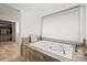Bright bathroom soaking tub with stone trim and a large window with shade at 7829 Nile Cir, Arvada, CO 80007