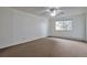 Bright bedroom featuring a large window, neutral carpet, and a ceiling fan with lights at 9340 E Center Ave # 8A, Denver, CO 80247