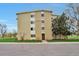Tan-colored building exterior with well-manicured lawn and mature trees in a park-like setting at 9340 E Center Ave # 8A, Denver, CO 80247