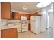 Functional kitchen with wood cabinets, white appliances, and neutral flooring at 9340 E Center Ave # 8A, Denver, CO 80247