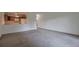 Spacious living room featuring neutral walls and plush gray carpeting adjacent to a breakfast bar and kitchen at 9340 E Center Ave # 8A, Denver, CO 80247