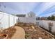 Backyard garden with brick-paved walkway and white vinyl privacy fence at 20764 E 47Th Ave, Denver, CO 80249