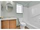 Bright bathroom featuring a tub and shower combination, a wooden vanity, and a window at 20764 E 47Th Ave, Denver, CO 80249