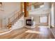 Bright and open living room with a fireplace, staircase, and views into the kitchen at 20764 E 47Th Ave, Denver, CO 80249