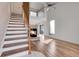 Bright living room with vaulted ceiling, fireplace, hardwood floors, and staircase at 20764 E 47Th Ave, Denver, CO 80249