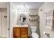 Cozy bathroom with a wood vanity, shelving, an oval mirror, and neutral wall paint at 3254 Red Tree Pl, Castle Rock, CO 80104