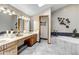 Luxurious bathroom with double vanity, soaking tub, marble countertops, and modern fixtures and lighting at 3254 Red Tree Pl, Castle Rock, CO 80104