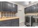 Well-equipped laundry room with modern washer and dryer, ample storage, and stylish tile backsplash at 3254 Red Tree Pl, Castle Rock, CO 80104