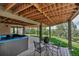 Relaxing covered patio with a hot tub and seating area overlooking the lush green landscape at 3254 Red Tree Pl, Castle Rock, CO 80104
