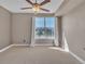 Bedroom featuring neutral colored walls, carpet, ceiling fan, and a window with neighborhood views at 9019 E Panorama Cir # D217, Englewood, CO 80112