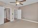 Bedroom featuring neutral colored walls, carpet, ceiling fan, and an open closet and ensuite bathroom at 9019 E Panorama Cir # D217, Englewood, CO 80112