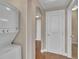 Hallway view featuring an in-unit washer/dryer and multiple white paneled doors at 9019 E Panorama Cir # D217, Englewood, CO 80112