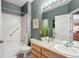 Cozy bathroom featuring a shower over tub and a wood vanity with ample lighting at 2015 Saddleback Dr, Castle Rock, CO 80104