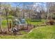 Backyard with a wooden bench with accent pillows and a trampoline in the background at 5752 S Jasmine St, Greenwood Village, CO 80111