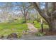 Spacious backyard featuring a stone pathway, mature trees, and manicured lawn at 5752 S Jasmine St, Greenwood Village, CO 80111