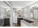 Bathroom with a dual sink vanity, dark cabinets, granite countertops, and decorative mirrors at 5752 S Jasmine St, Greenwood Village, CO 80111